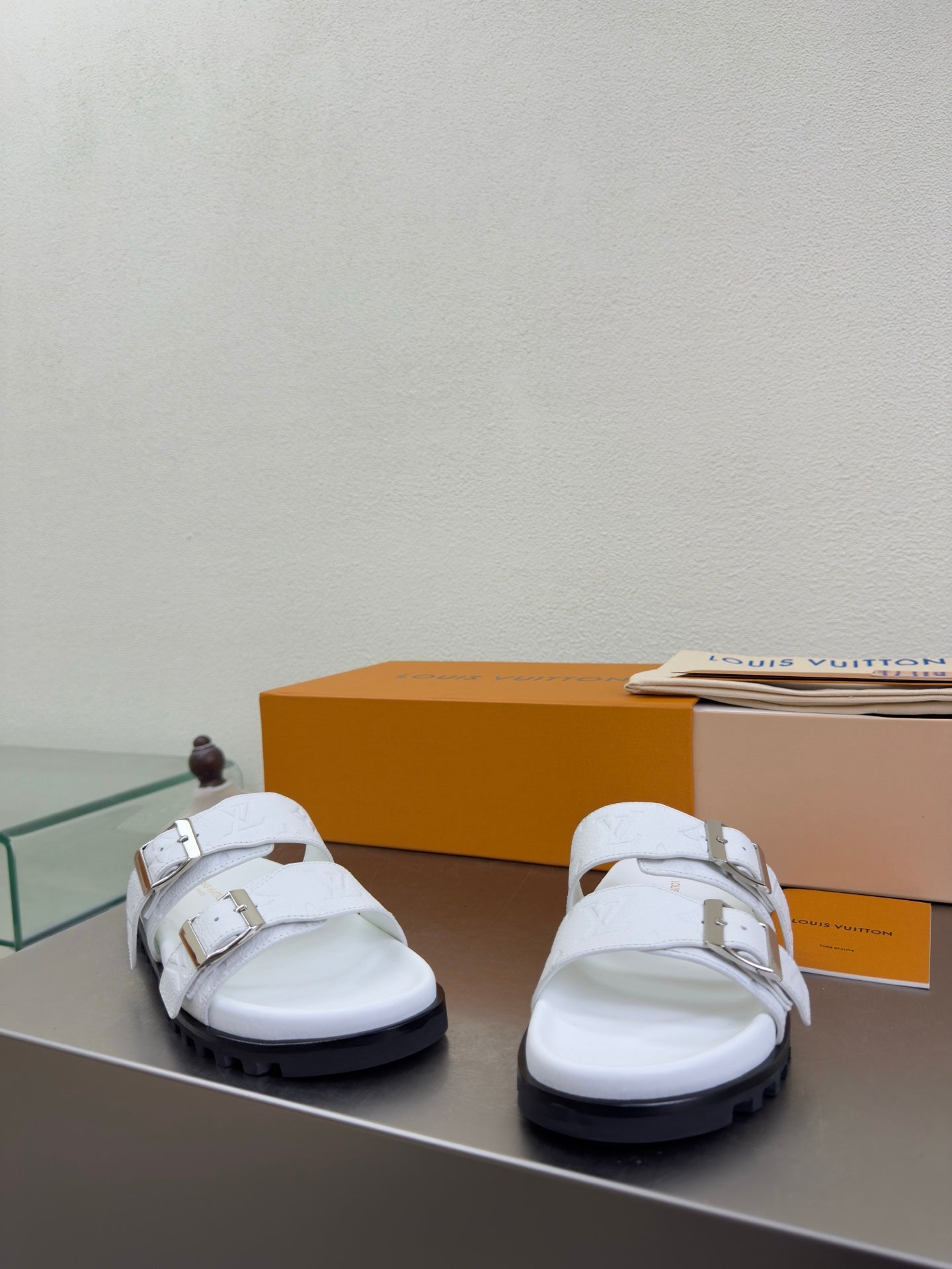 White Louis Vuitton sandals on display, chunky sole with dark outsole edge