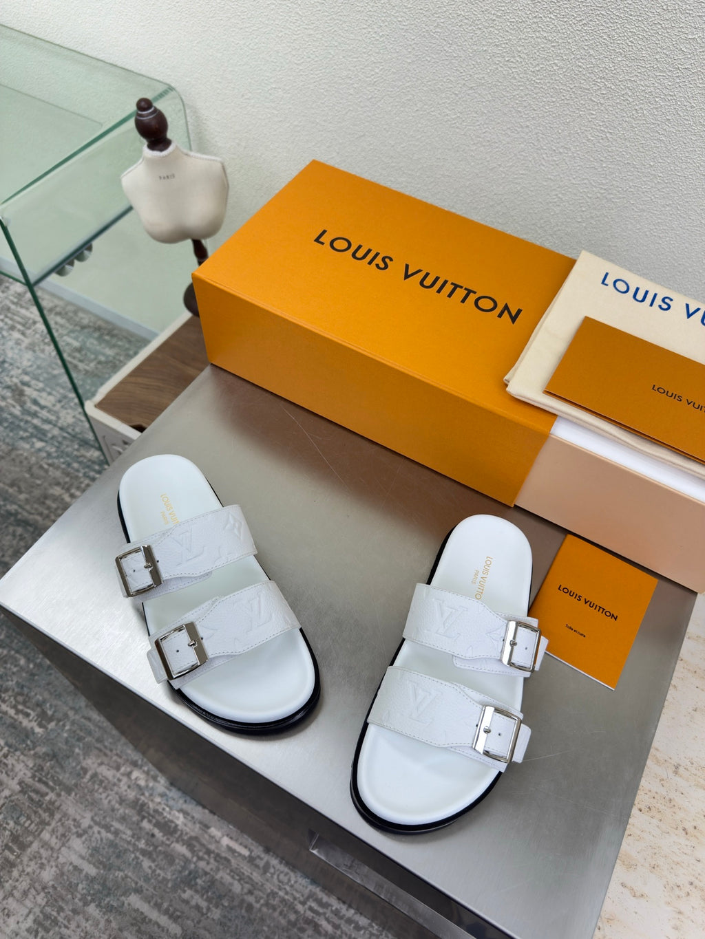White Louis Vuitton sandals with two buckle straps and embossed logo-pattern upper