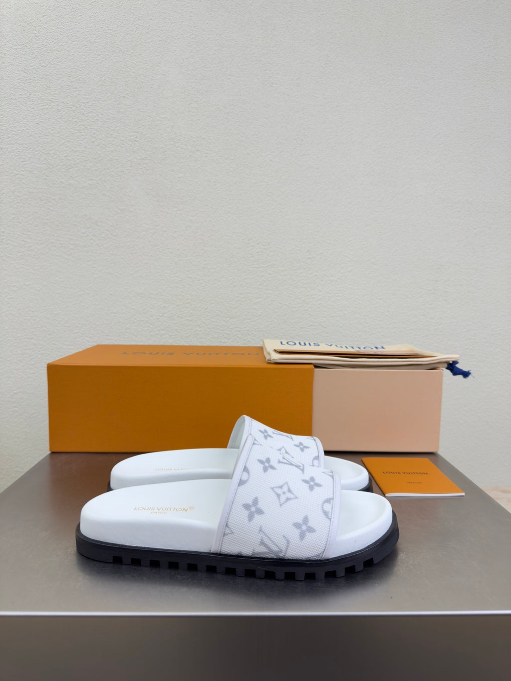 White monogram slide sandals with thick sole and strap detail