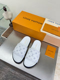 White monogram slide sandals with wide strap and black rubber sole