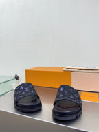 Louis Vuitton slide sandals with dark upper and blue monogram pattern, rear view