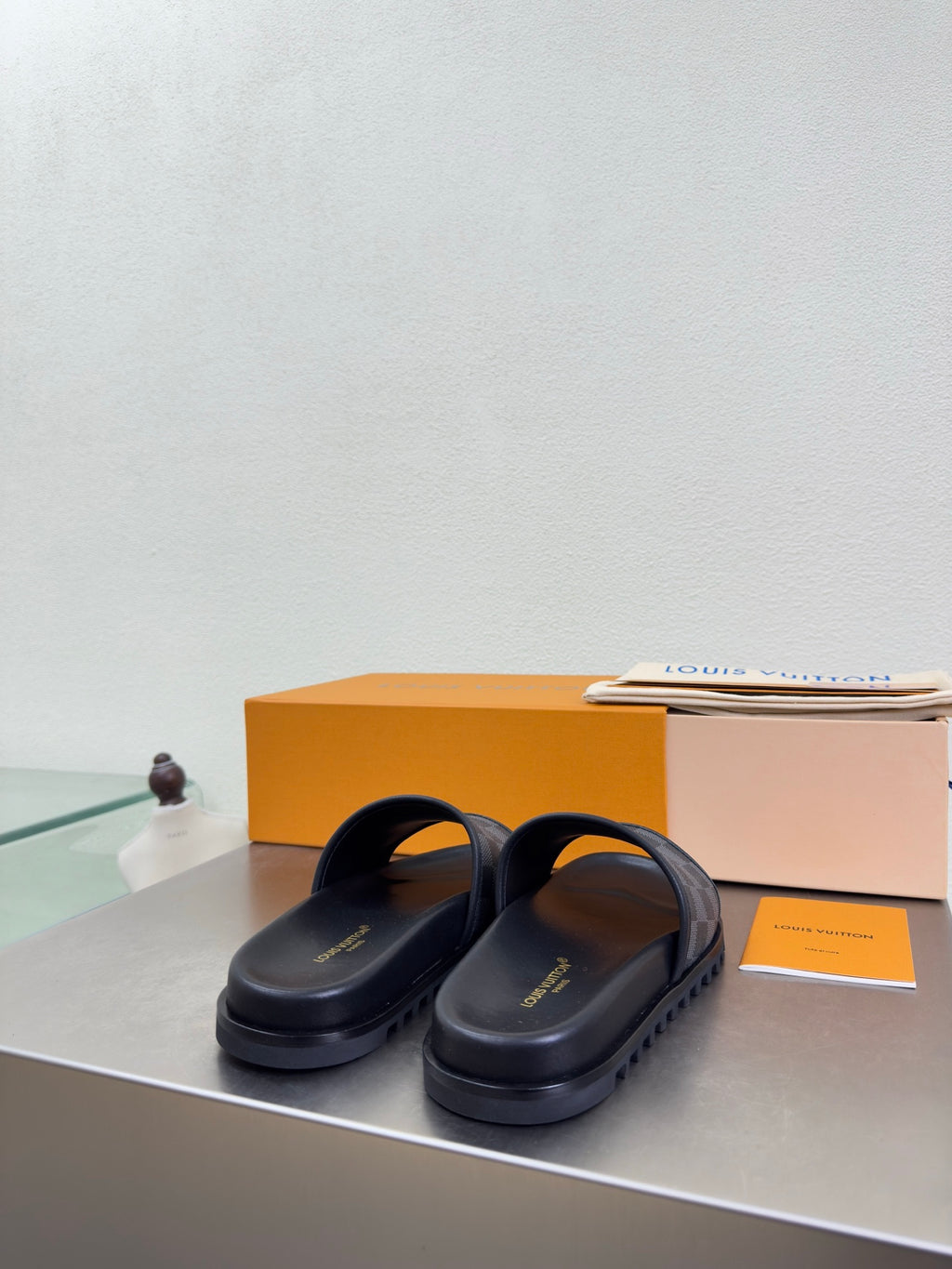 Louis Vuitton slide sandals with dark leather straps and check-pattern band