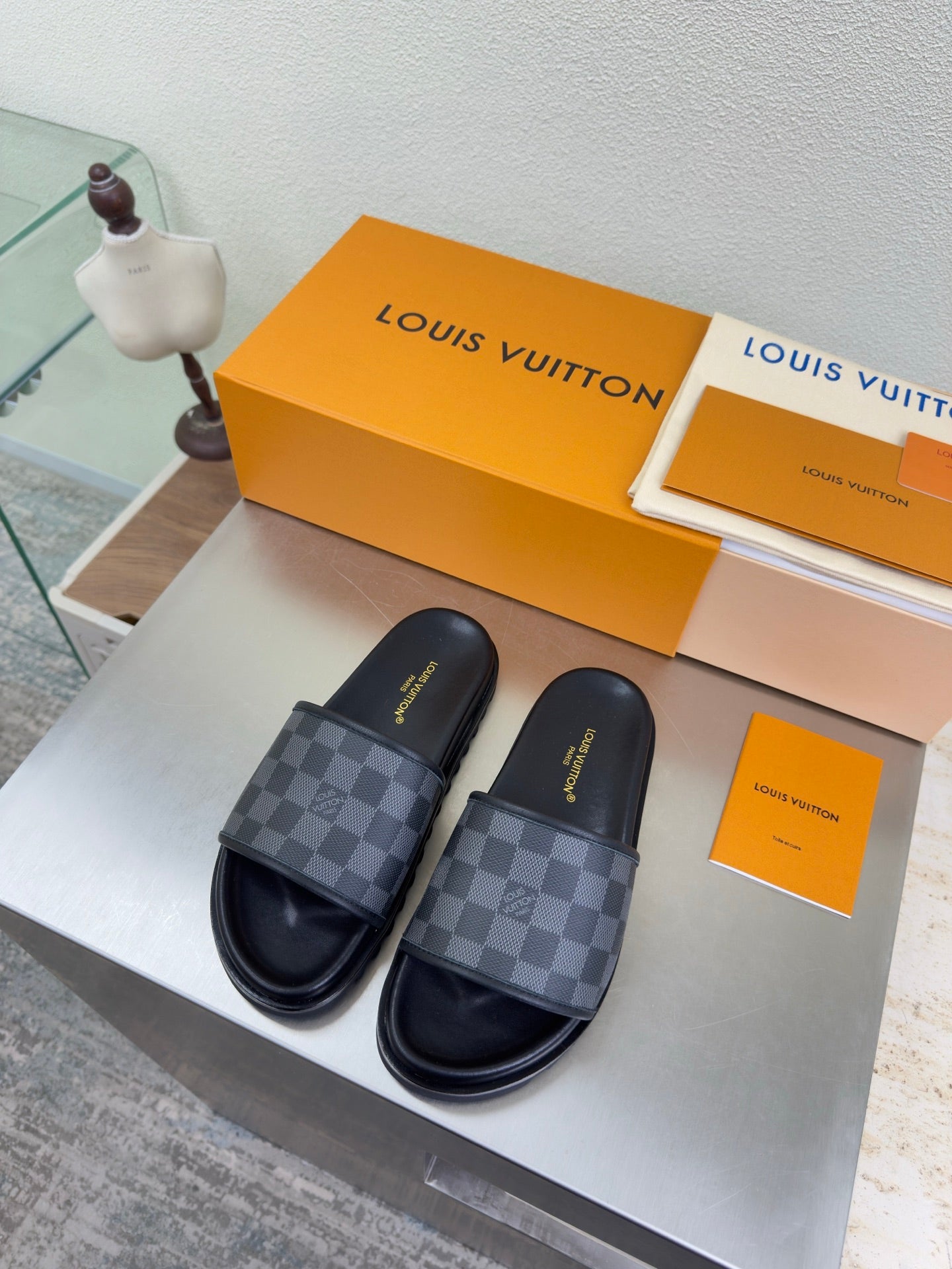 Louis Vuitton slide sandals with dark check-pattern straps and cushioned footbed