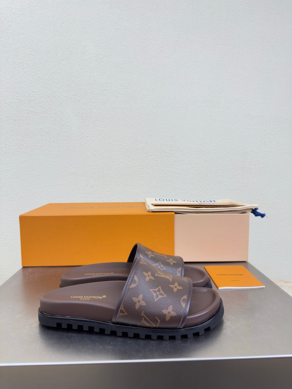 Louis Vuitton monogram slide sandal with dark brown footbed and tread sole