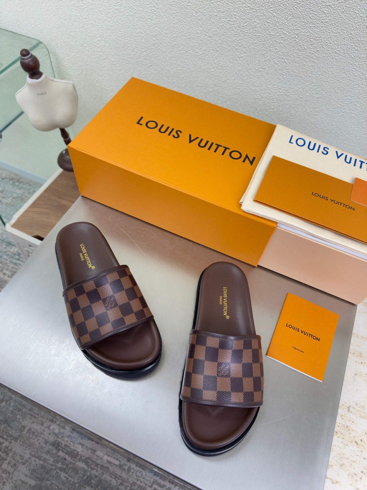 Louis Vuitton damier check slide sandals, brown leather straps and dark rubber sole.