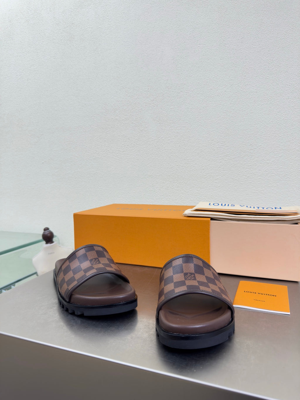 Louis Vuitton damier check slide sandals, brown with raised footbed and thick outsole.