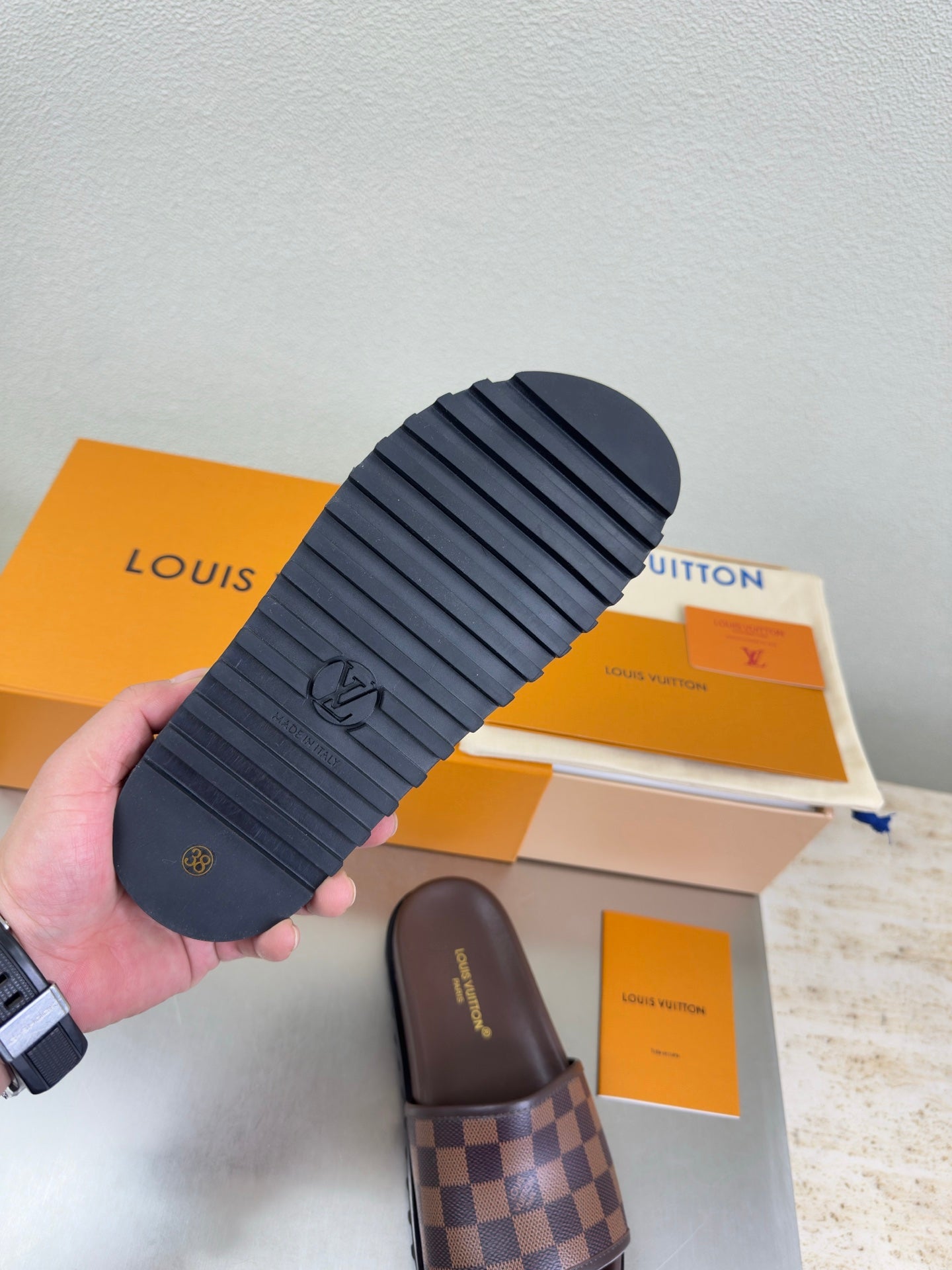 Louis Vuitton slide sandal outsole, dark rubber tread with embossed Louis Vuitton emblem.