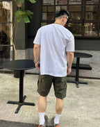 Olive cargo shorts with side seams and cuffed hem, 3/4 rear angle