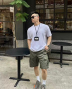 Olive cargo shorts with cargo pockets and mid-thigh length, side view