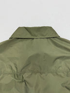 Olive green short-sleeve jacket with back collar and yoke seam detail.