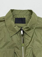 Olive green short-sleeve zip jacket with structured collar and silver zipper pull.