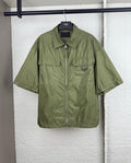 Olive green short-sleeve zip jacket with two chest pockets and Prada triangle logo.