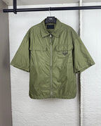Olive green short-sleeve zip jacket with two chest pockets and Prada triangle logo.