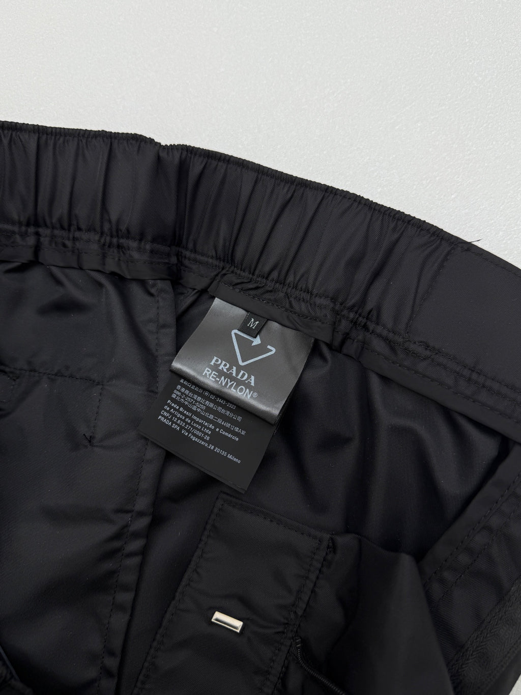 Prada black cargo shorts with hanging care label and side pocket