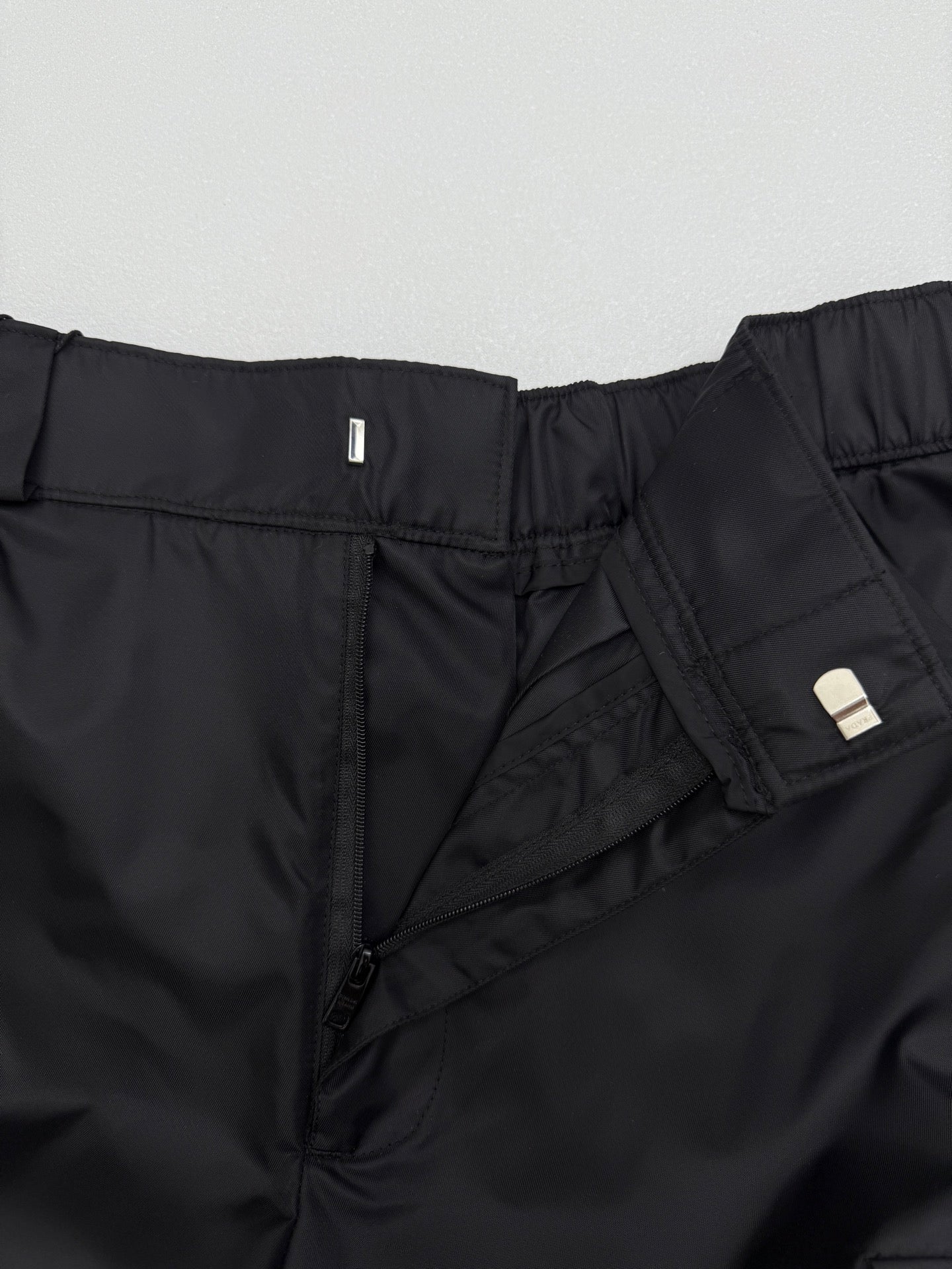 Prada black cargo shorts close-up of zip fly and inner pocket