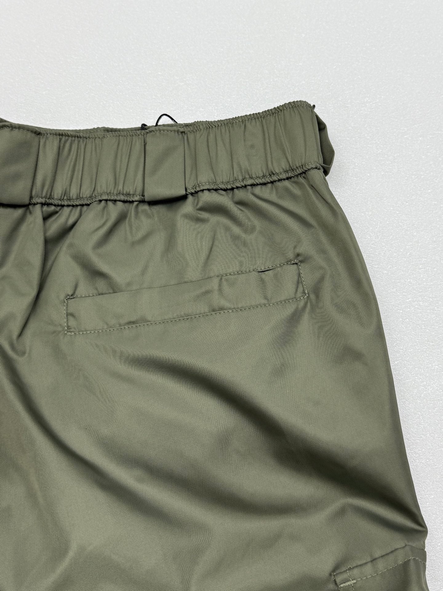 Olive cargo shorts with elastic waistband and stitched back seam