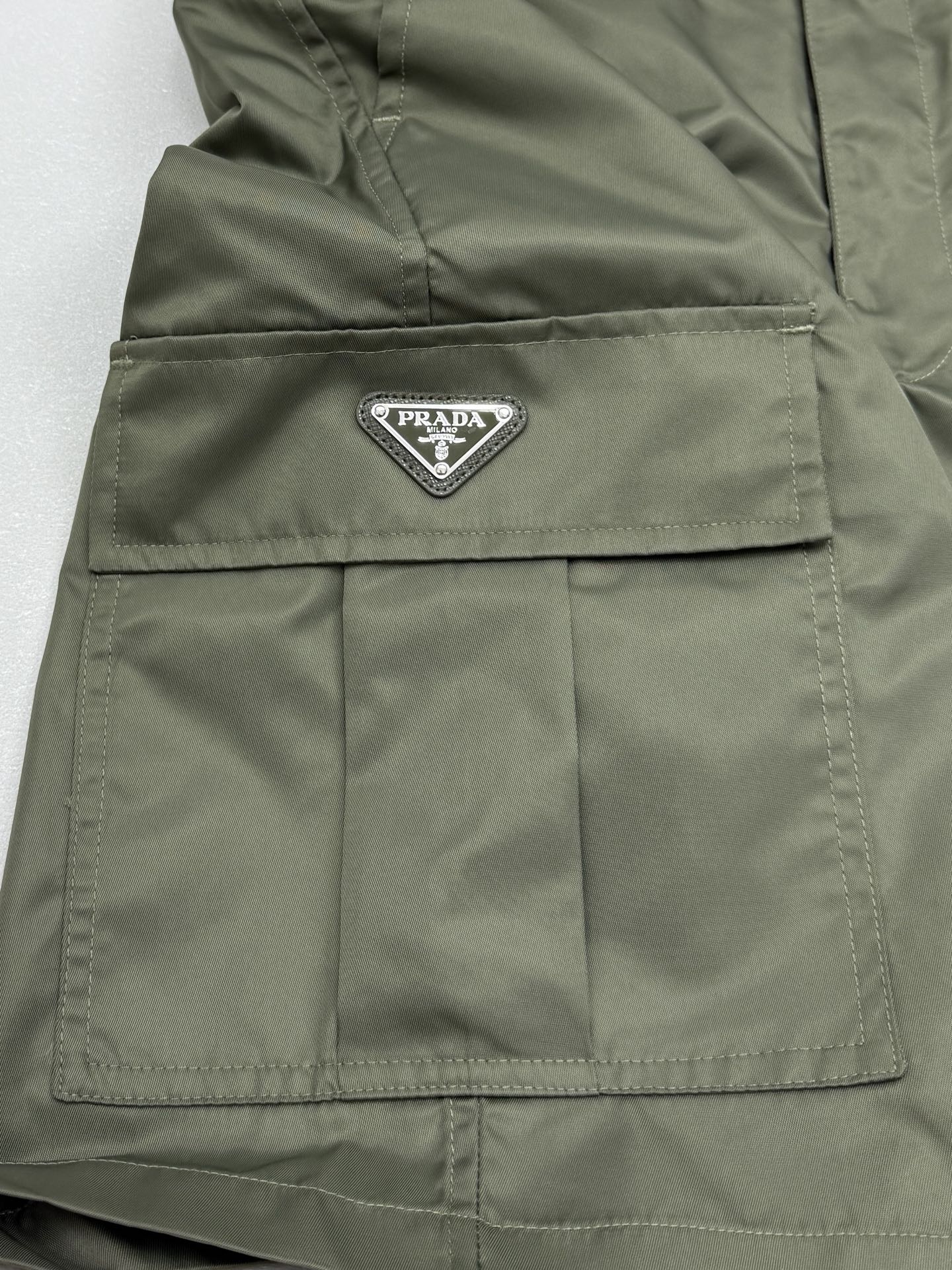 Olive cargo shorts with PRADA logo patch on front cargo pocket