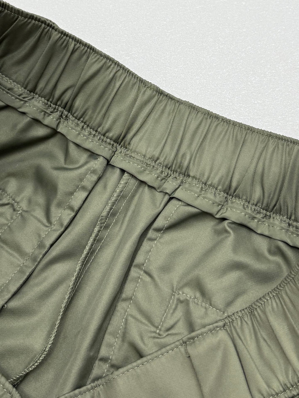 Olive cargo shorts with elastic waistband stitching and back yoke