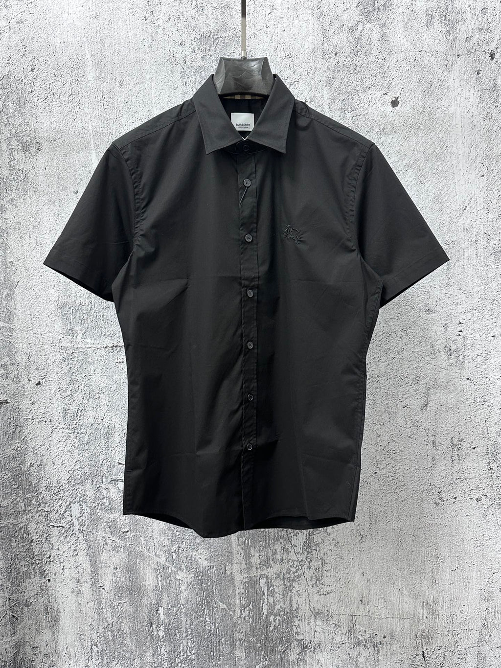 Black short-sleeve button-up shirt with spread collar and front button placket