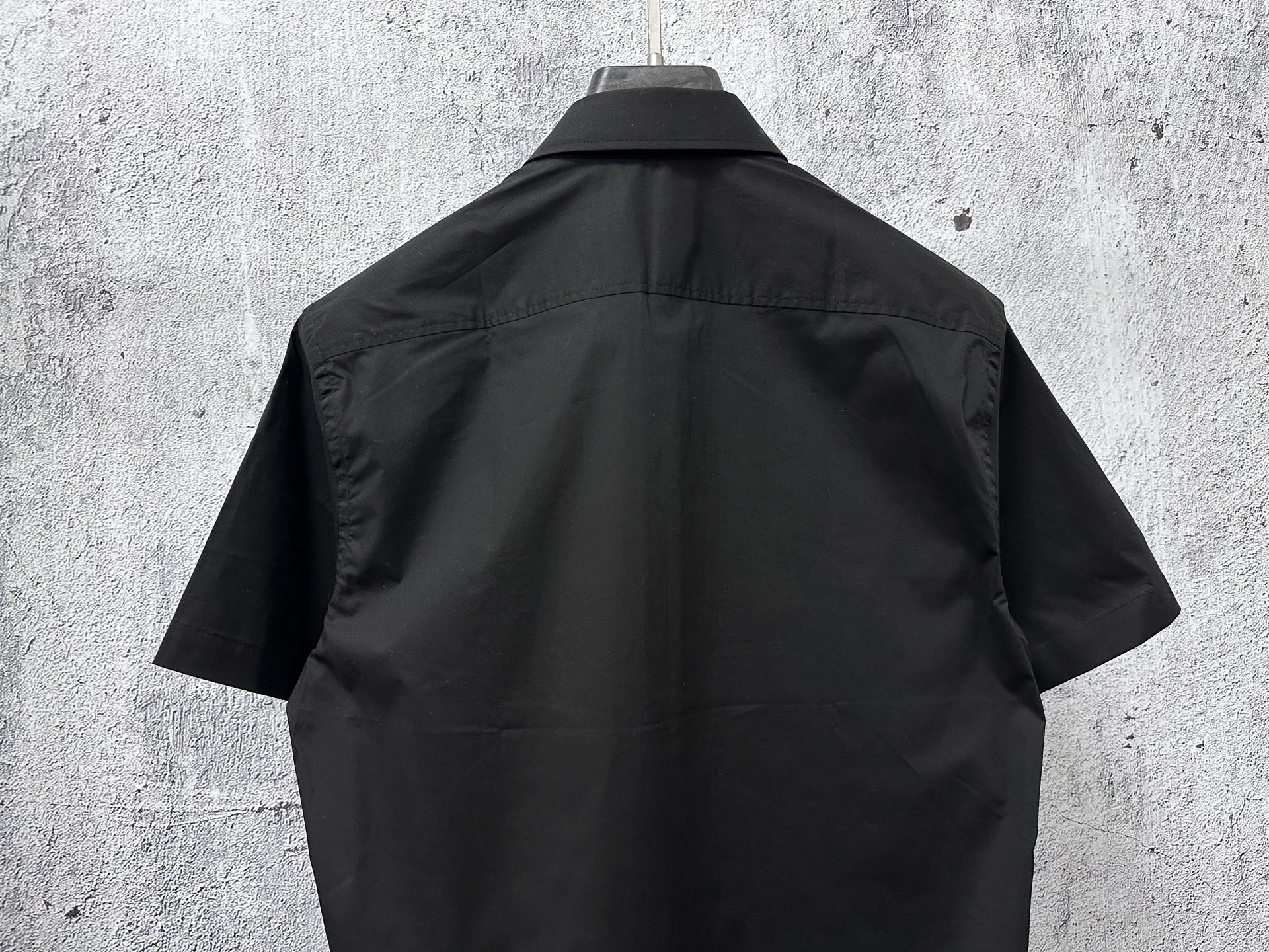 Short-sleeve button-up shirt, dark black, back view with yoke and short sleeves