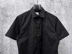 Black short-sleeve button-up shirt with chest logo detail and front buttons