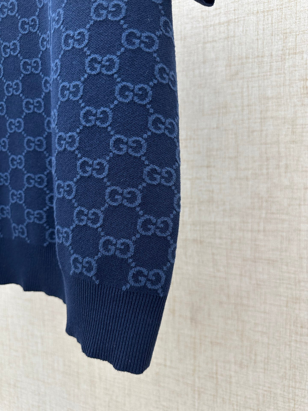 Dark navy polo shirt side view, ribbed cuff and knit hem