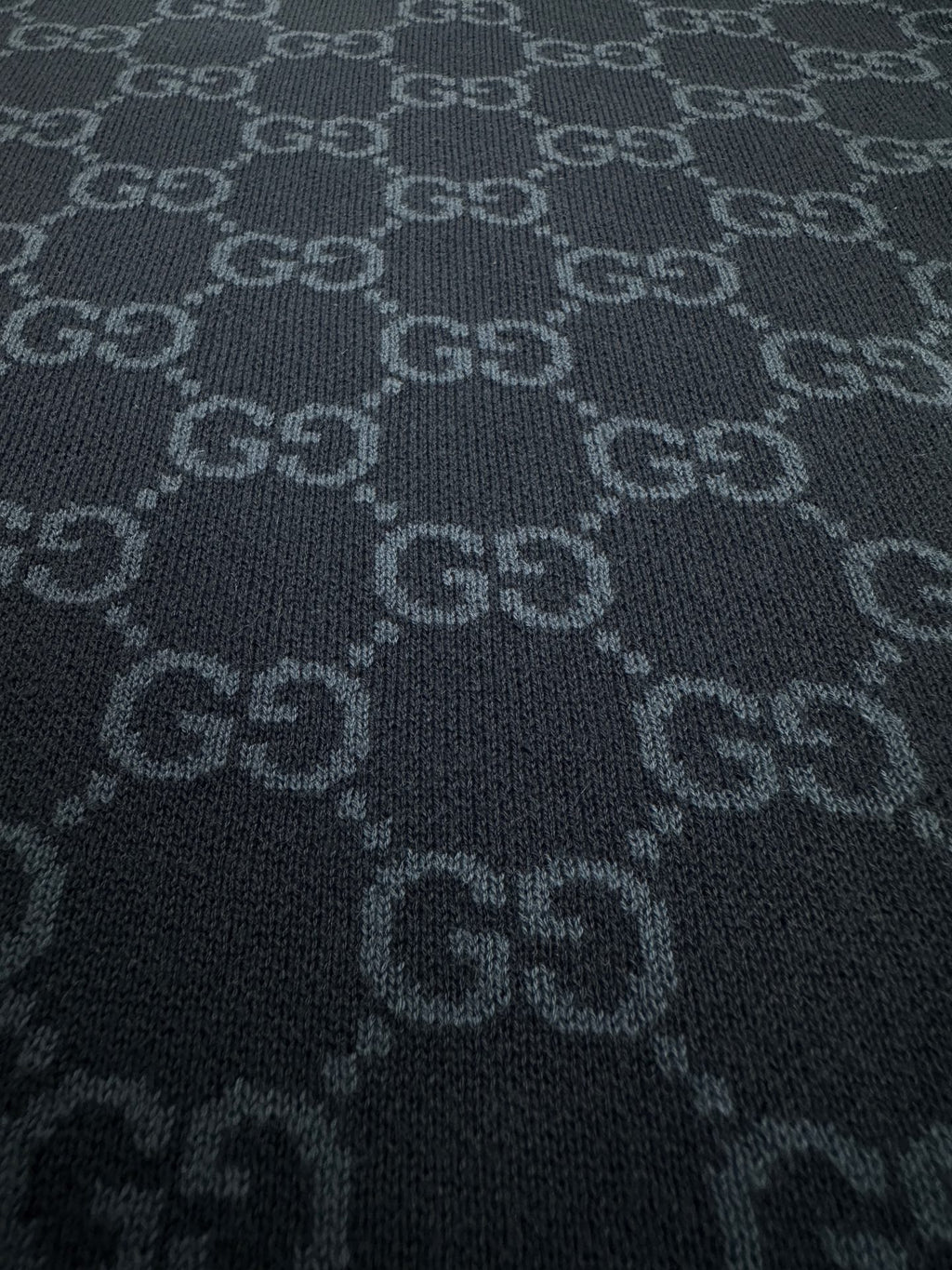 Dark navy knit fabric with repeating GG monogram motif