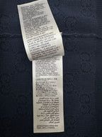 Navy polo shirt care instructions tag with washing symbols and text
