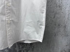 White short-sleeve button-up shirt hem with side seam stitching