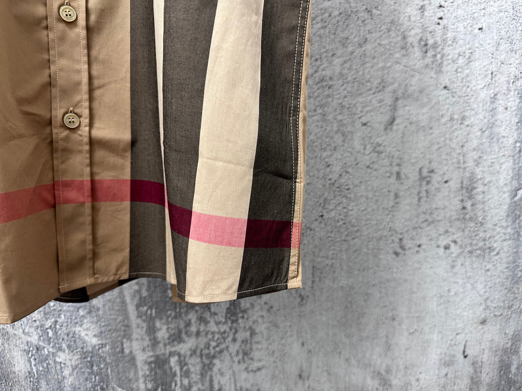Side hem and sleeve cuff detail on beige, black, and red plaid shirt