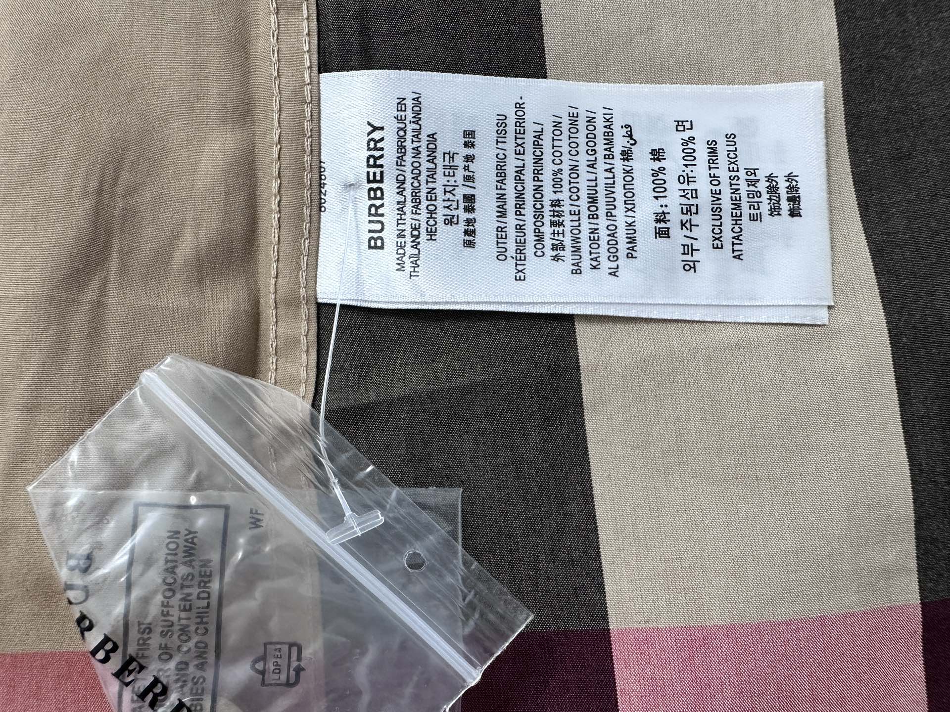 Burberry size label and care tag inside collar on beige, black, and red plaid shirt
