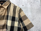 Short-sleeve shirt collar and shoulder detail, beige, black, and red plaid