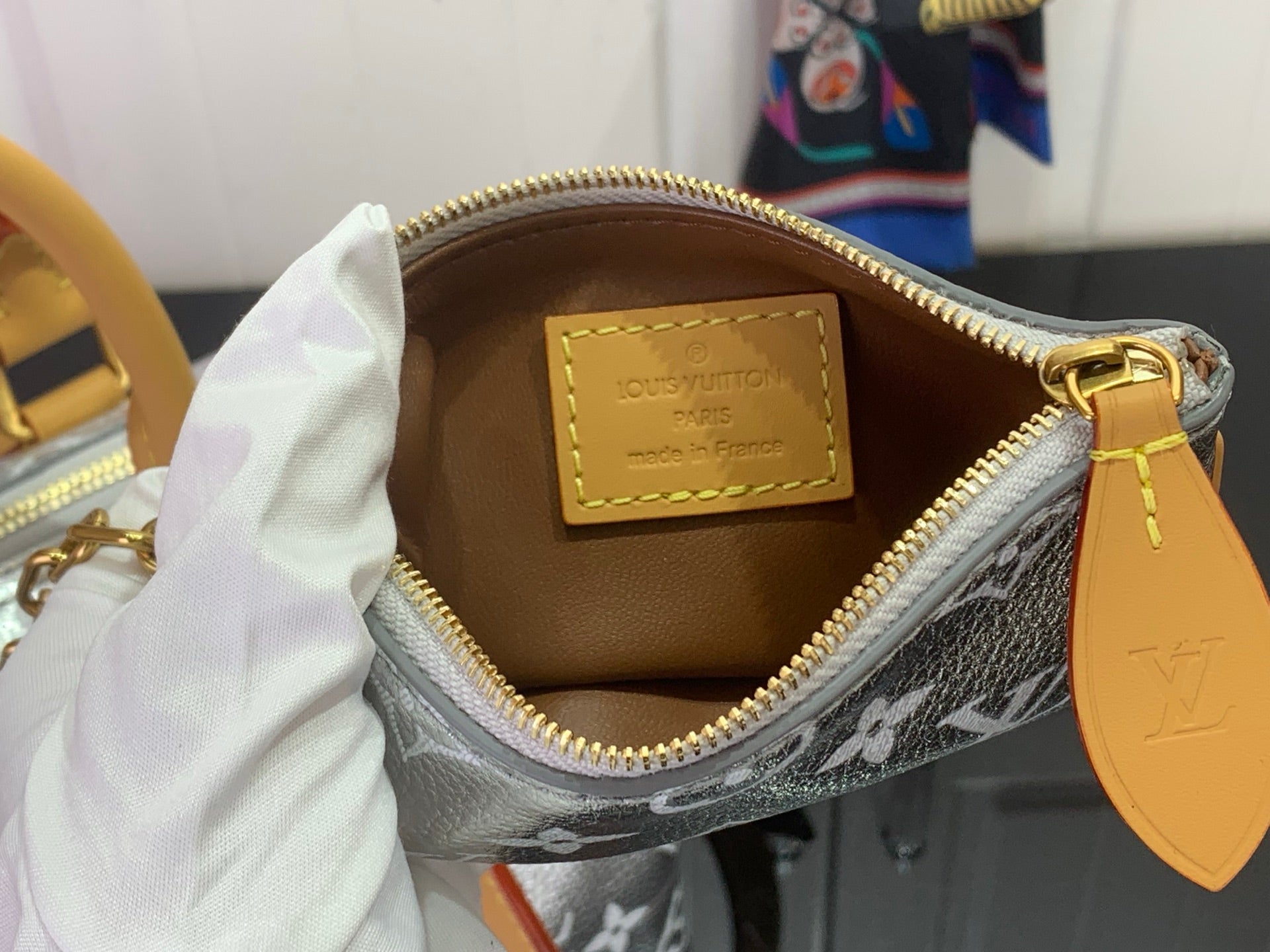 Louis Vuitton bag interior with tan leather label and zip top