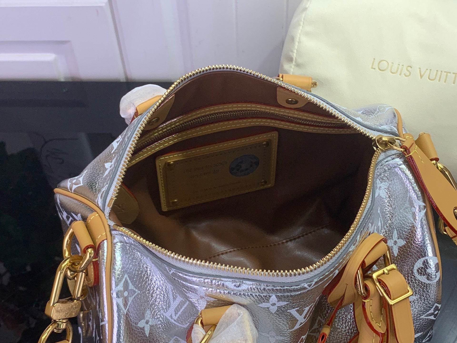 Louis Vuitton bag interior with tan lining, zip opening and gold-tone hardware