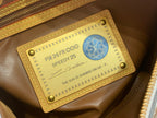 Louis Vuitton bag authenticity tag on tan leather patch with blue emblem