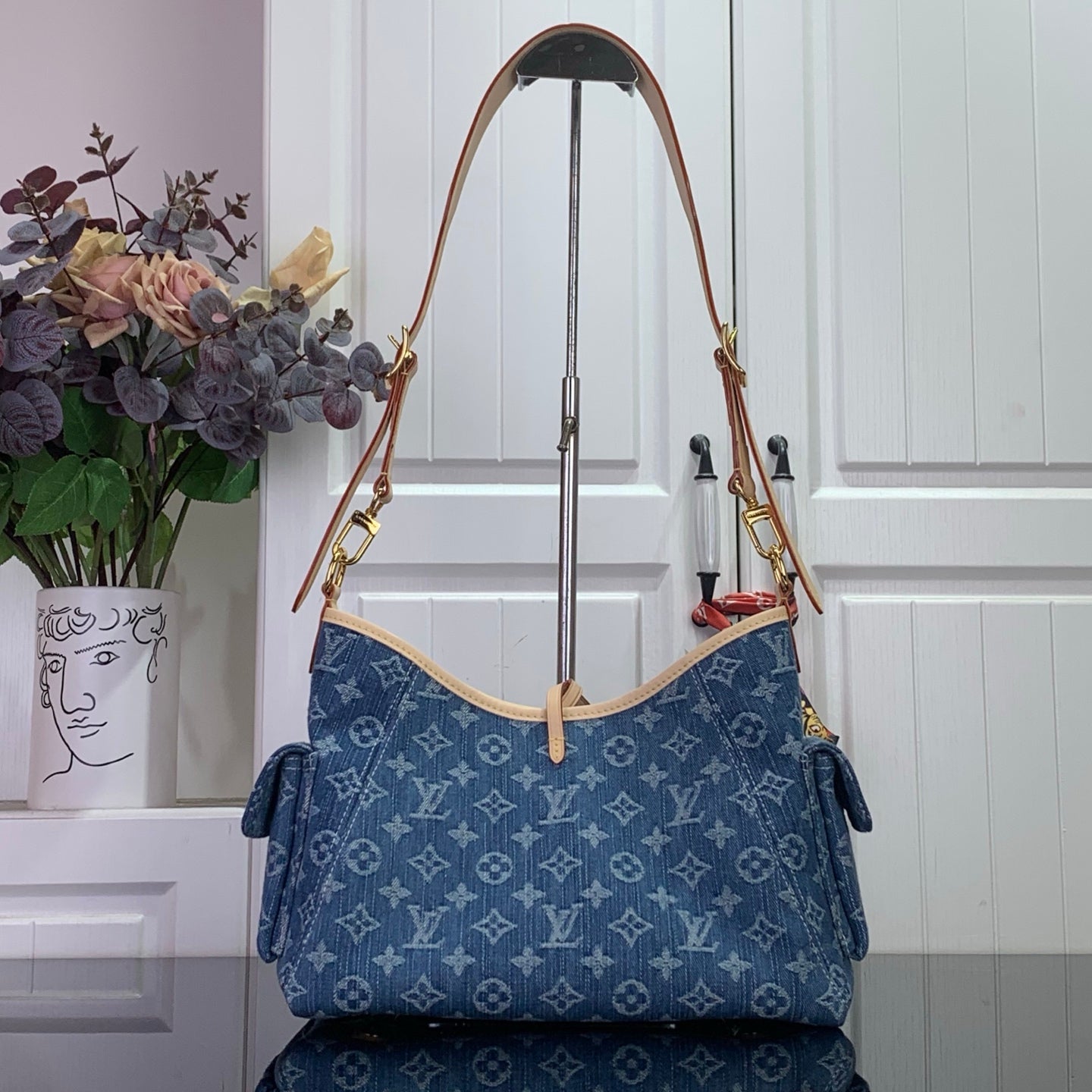Blue monogram tote bag with tan top handles and gold rings, gathered side tabs
