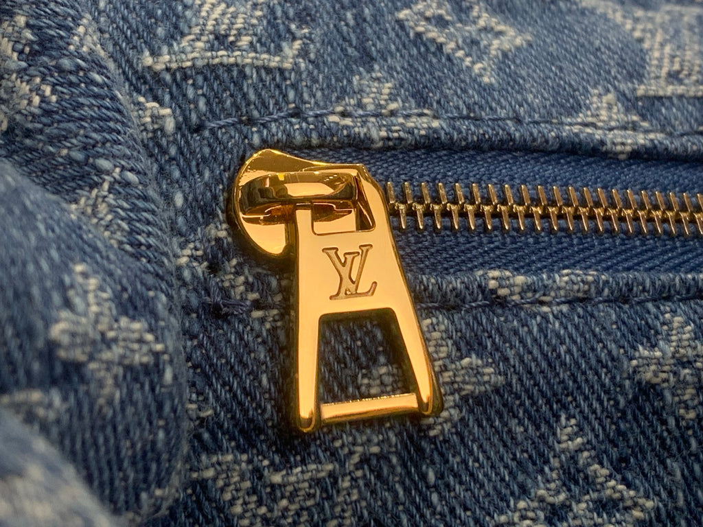 Louis Vuitton bag zipper pull with LV monogram, gold-tone on blue denim