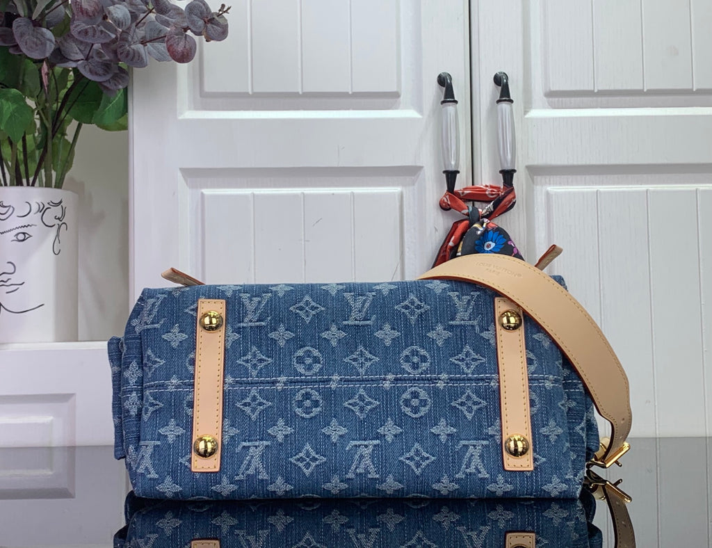 Blue monogram tote bag top section with tan flap, gold snaps, and leather straps