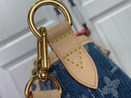 Gold handle hardware and tan strap on blue monogram tote bag