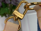 Gold-tone metal D-ring clasp with tan leather strap on denim monogram bag