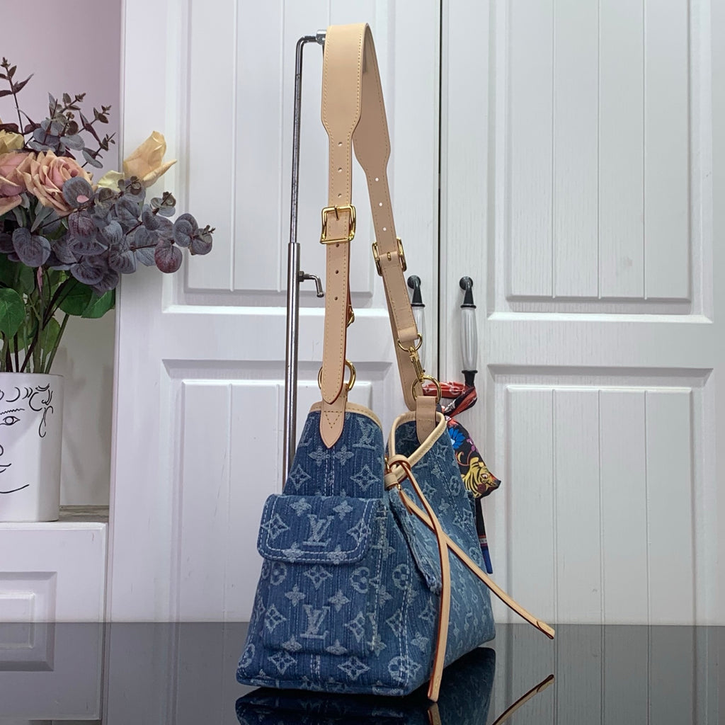 Denim monogram shoulder bag with tan strap, gold clasps, and top handles