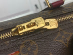 Gold zipper pull and track on monogram bag close-up
