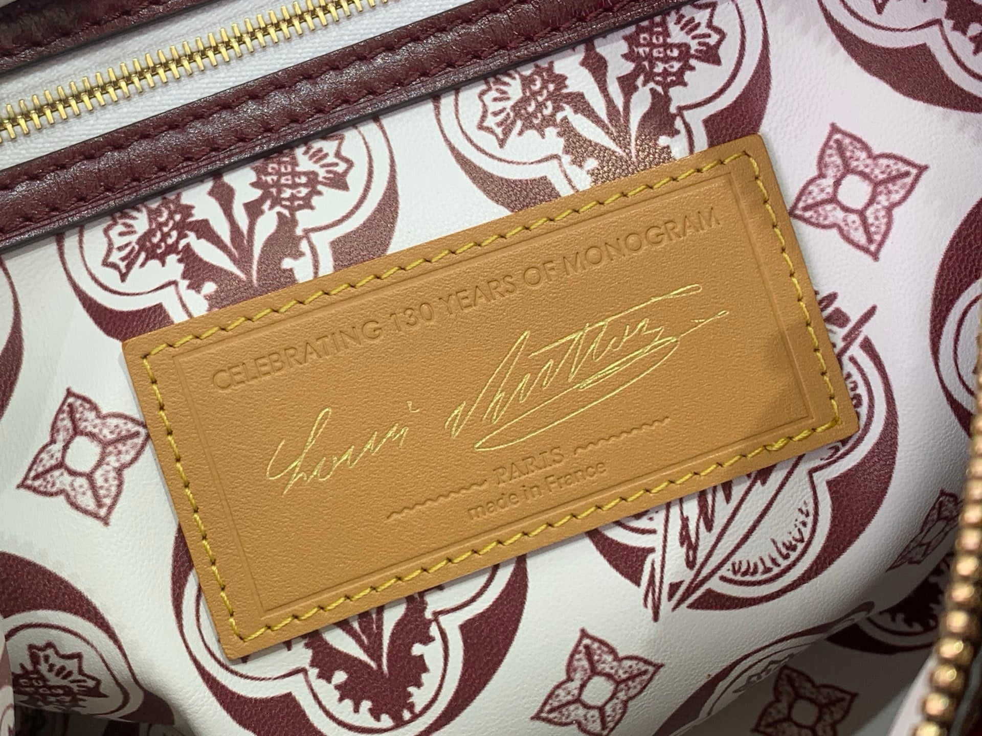 Leather card holder label on patterned lining inside monogram bag