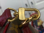 Gold swivel clasp with burgundy leather strap on monogram bag