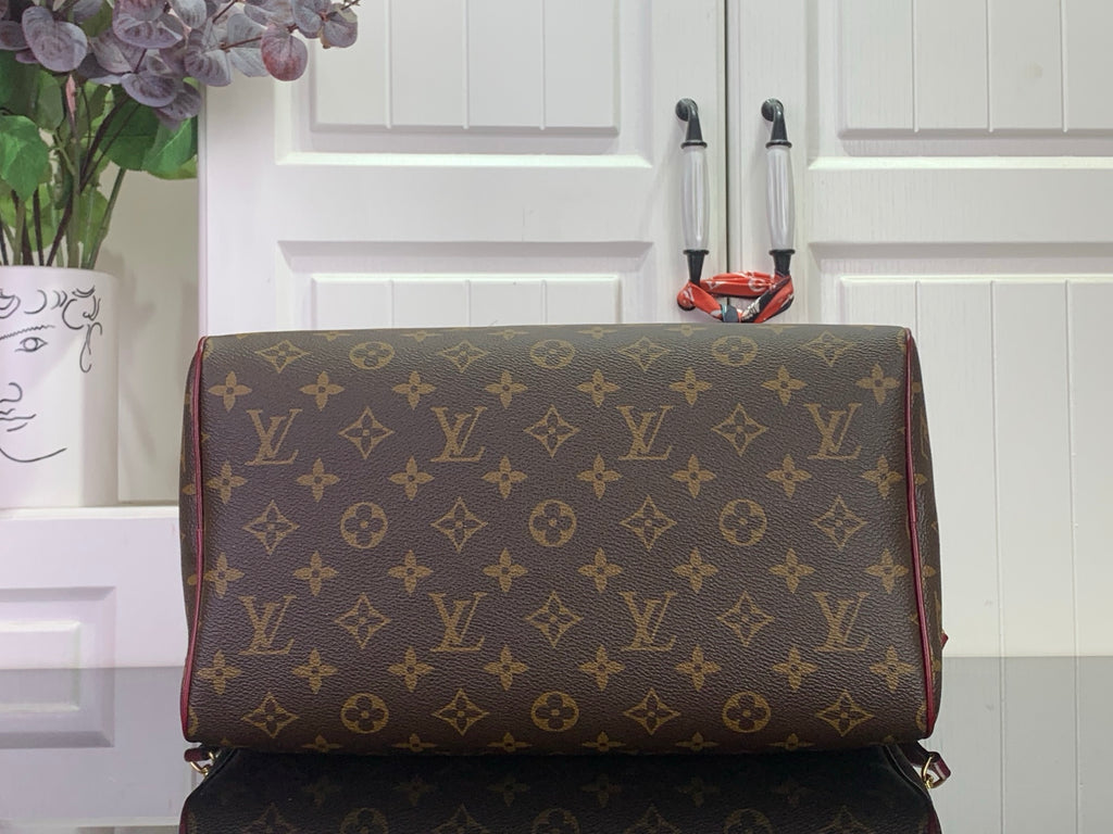 Monogram duffel-style bag with burgundy piping and gold hardware