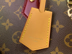 Yellow luggage tag with Louis Vuitton text on monogram bag handle