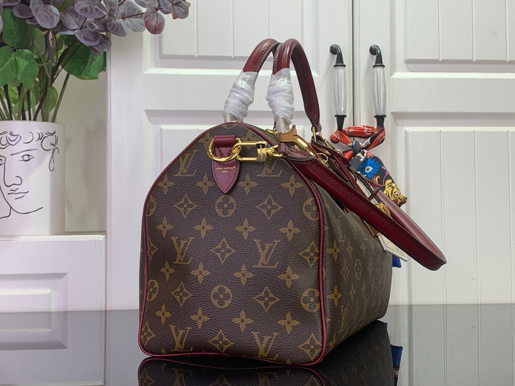 Monogram tote bag with burgundy handle, side view, and gold hardware