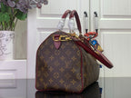 Monogram tote bag with burgundy handle, side view, and gold hardware