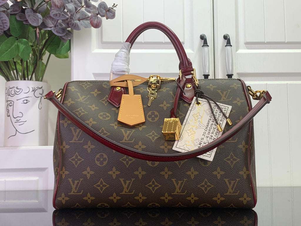 Monogram top-handle bag with burgundy trim and gold hardware