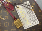 Gold tag charm and white luggage label on monogram bag strap